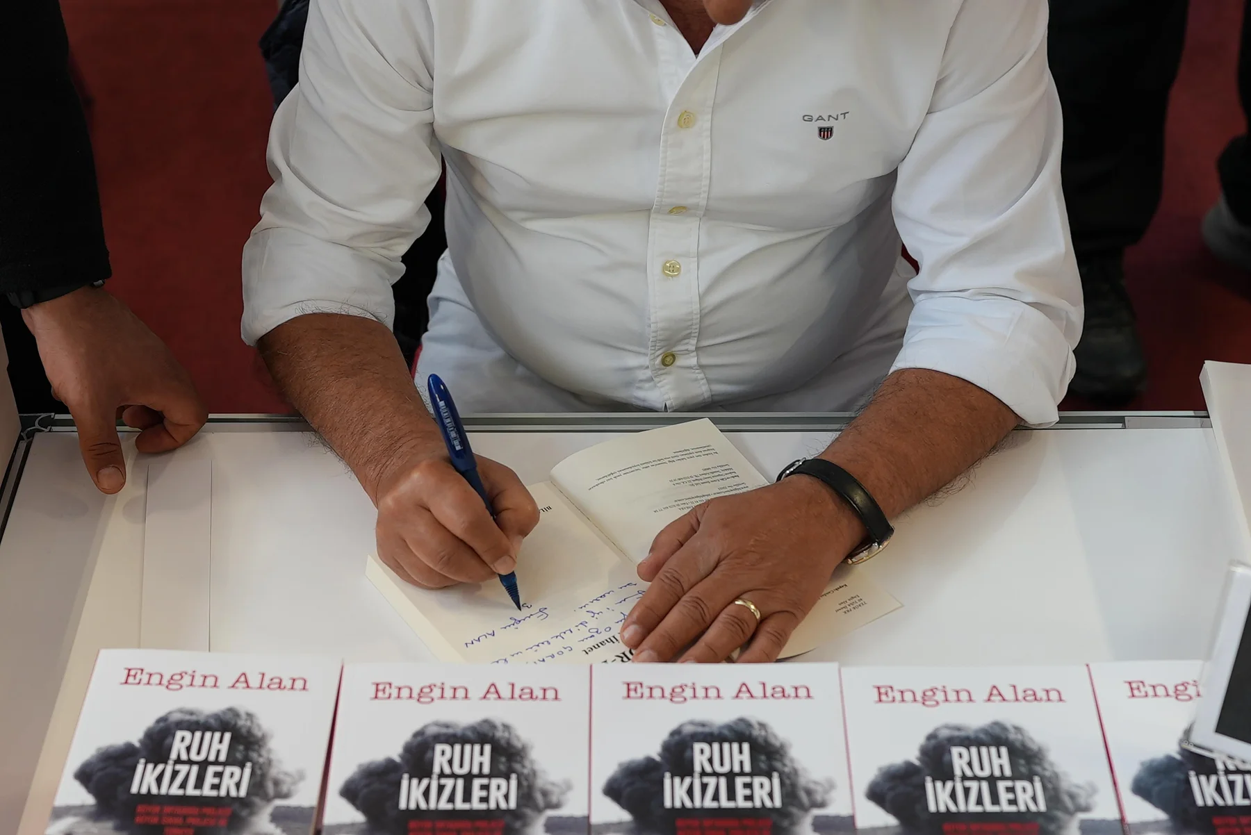İmza masasında bir kitabın içine ithaf yazılması